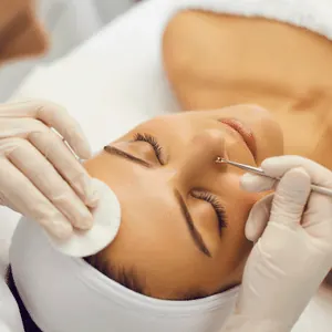 Profissional realizando limpeza de pele facial
